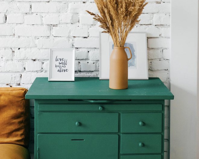 A green dresser against a white wall